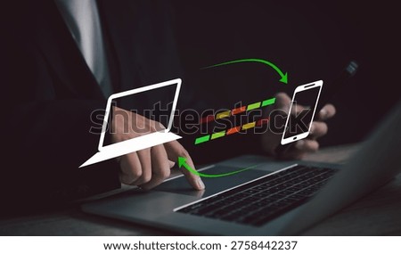 businessman manages data synchronization between laptop and smartphone, seamless integration in modern technology, efficient workflow, connectivity, and real-time updates for maximum productivity.
