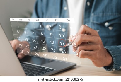 Businessman manages time for effective work. Calendar on the virtual screen interface. Highlight appointment reminders and meeting agenda on the calendar. Time management concept. - Shutterstock ID 2245082975