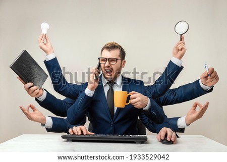 Businessman with many hands in a suit. Works simultaneously with several objects, a mug, a magnifying glass, papers, a contract, a telephone. Multitasking, efficient business worker concept