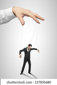 Businessman marionette on ropes controlled  hand
