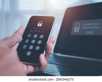 Businessman with a mobile phone and laptop computer is secure in his account. The concept is hacking a Phishing mobile phone with a password to access a smartphone, security threats online, and fraud.