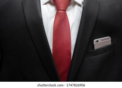 Businessman With Mobile Phone In Pocket. Closeup Of Confident Business Man Wearing Elegant Suit With Mobile Phone In Pocket.