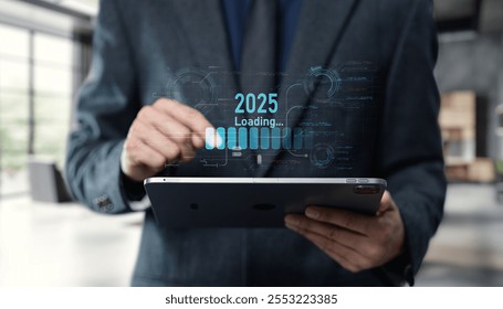 A businessman in a modern office setting interacts with a tablet displaying a futuristic loading graphic, symbolizing data transition and innovation for 2025.