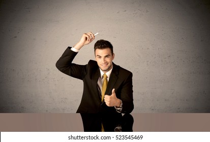 A Businessman In Modern Stylish Elegant Suit Standing On A Small Ladder And Drawing Pie And Block Charts On Grey Wall Background With Exponential Progressing Curves, Lines, Circles, Angles, Numbers