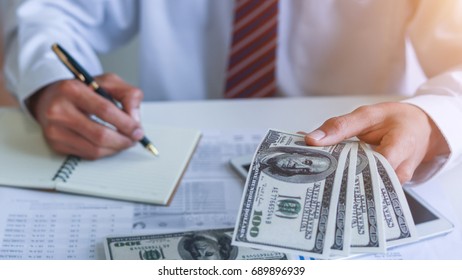 Businessman with money in hand, US dollar,investment, success and profitable business concepts.