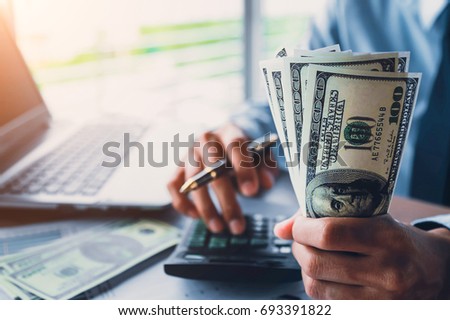 Businessman with money in hand, US dollar,investment, success and profitable business concepts.