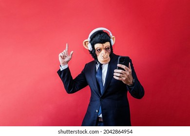 Businessman in monkey mask dancing with headphones and smartphone - Powered by Shutterstock