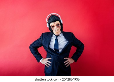 Businessman in monkey mask looking at camera with headphones - Powered by Shutterstock