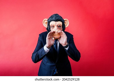 Businessman in monkey mask yelling with his hands on his mouth.