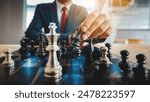 Businessman moving chess piece on chess board game concept for ideas and competition and strategy, business success concept, business competition planning teamwork strategic concept.	