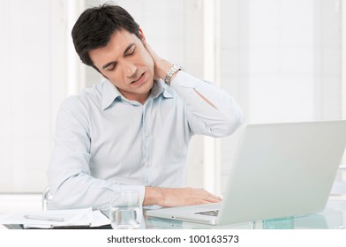 Businessman With Neck Pain After Long Hours At Work