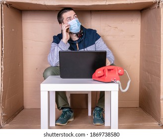 businessman negotiating by phone, sitting in a cardboard office
