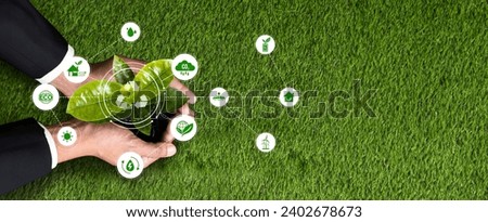 Businessman nurturing and holding plant with recycle symbol. Business commitment and investing in natural and environmental protection future sustainable ecosystem. Panorama Reliance