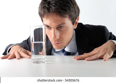 Businessman Observing A Half Full Glass Of Water