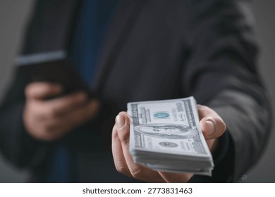 Businessman offering stack of US dollar banknotes representing cash payment, financial transaction, business investment, funding support, money exchange and wealth management concept in modern economy