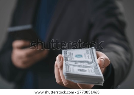Businessman offering stack of US dollar banknotes representing cash payment, financial transaction, business investment, funding support, money exchange and wealth management concept in modern economy