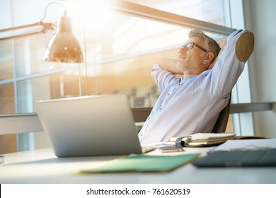 Businessman in office relaxing in chair