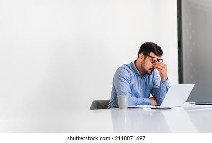 Businessman office working holding sore head pain from desk working and sitting all day using laptop computer or notebook suffering headache sick worker overworking concept - Shutterstock ID 2118871697