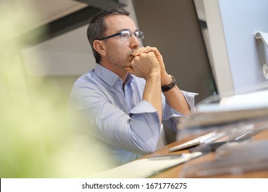 Businessman In Office Working On Desktop Computer, Thoughtful Look