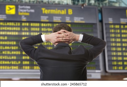 Businessman On A Background Of Departure Board At Airport 