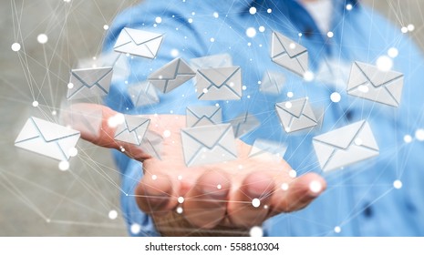 Businessman On Blurred Background Holding 3D Rendering Flying Email Icon In His Hand