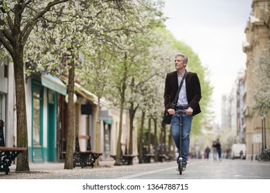 Businessman On Daily Commute Riding Micro Scooter