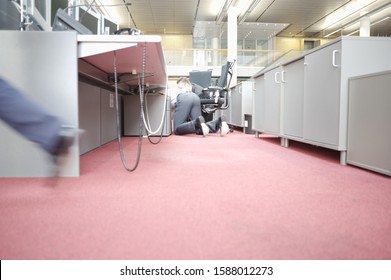 Businessman On Floor Under Desk