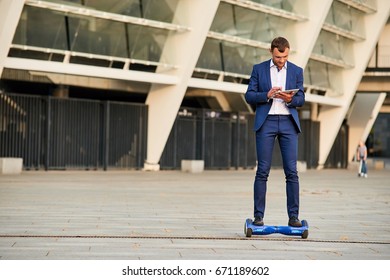 Businessman On Hoverboard. Guy With A Tablet.