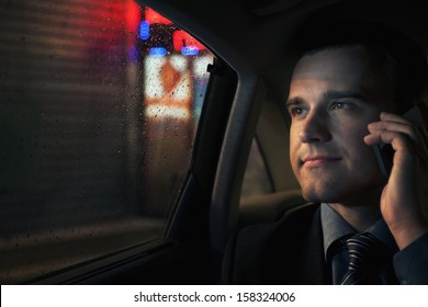 Businessman On The Phone In Backseat Of Car Looking Into Window