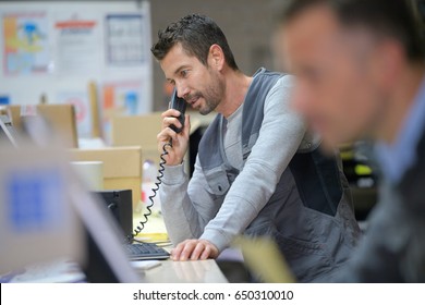 businessman on phone at warehouse - Powered by Shutterstock