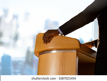 Businessman on podium speaking at conference with windows - Powered by Shutterstock