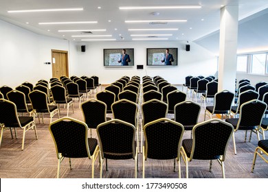 Businessman on projection screen testing connection before a seminar in conference hall.