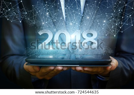 Businessman on tablet shows the numbers 2018. The concept of a new year.