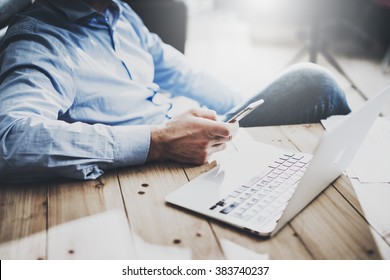 Businessman on workspace. Texting message smartphone. Generic design notebook wood table. Horizontal mockup.