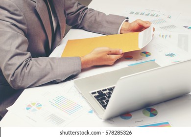 Businessman Open Brown Envelope For Evaluating Business Report, Examining Report Papers On Table In Desk Office.