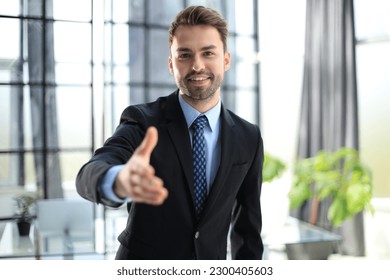 Businessman with an open hand ready to seal a deal. - Powered by Shutterstock