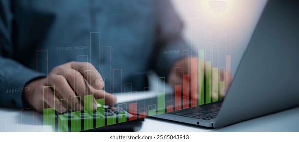 Businessman operating a calculator and laptop with digital bar charts and financial data overlays. business analytics, financial management and data-driven decision-making for modern enterprises - Powered by Shutterstock