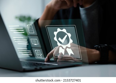 A businessman operating with the quality assurance, guarantee, standards, ISO certification, and standardization notion as a proof of top service. - Shutterstock ID 2153727401