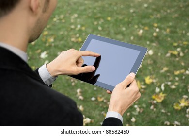 Businessman outdoors working with touch screen device. - Powered by Shutterstock