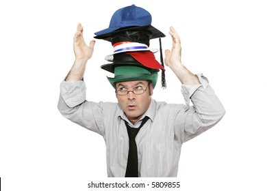 A businessman overwhelmed by too much responsibility - wearing too many hats.  Isolated on white.