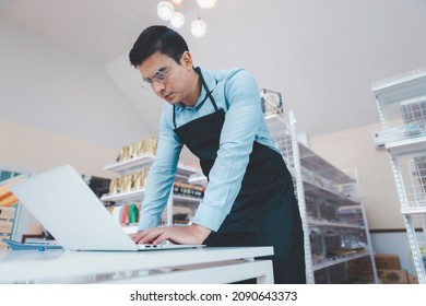 Businessman Owner Staff Using Computer Laptop Checking Product Inventory Shelf In Grocery Store