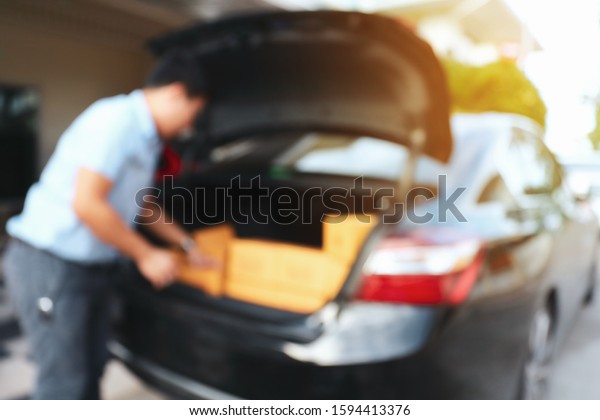 businessman\
packing box in car preparing express delivery for order customer,\
image blur logistic business\
background