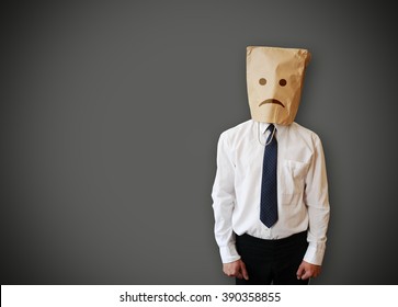Businessman with a paper bag with sad face on the head