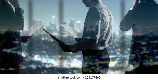 businessman with paper standing in night office - Powered by Shutterstock