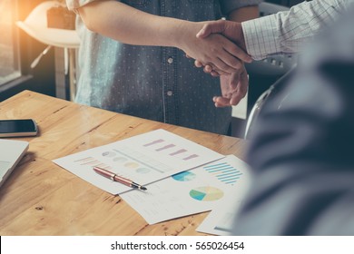 Businessman and partner shaking hands in office