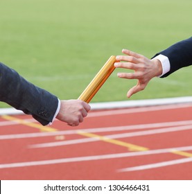 Businessman Passing Baton In Relay Race