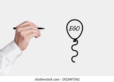 Businessman With A Pen Is About To Pop A Balloon Icon With The Word Ego. Lower Or Free Your Ego Concept.

