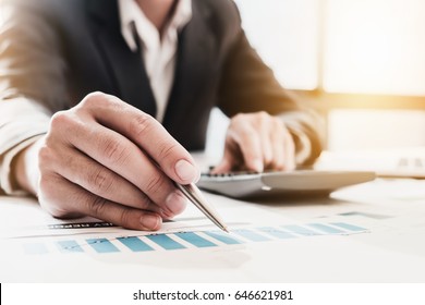 Businessman Pen Pointing Graph Chart In This Mounth And Use Calculator For  Plans To Improve Quality Next Month.