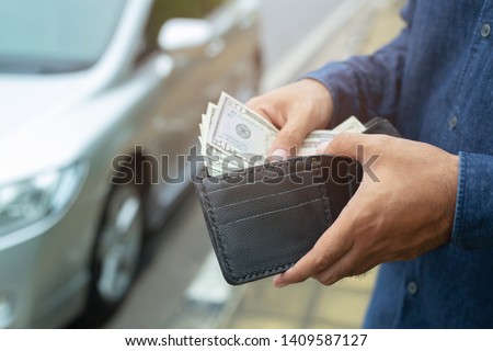 Businessman Person holding a wallet in the hands of take money out of pocket stand front car prepare pay by installments - insurance, loan and buying car finance concept insurance, payment a car
