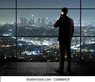 businessman with phone looks in night city - Powered by Shutterstock